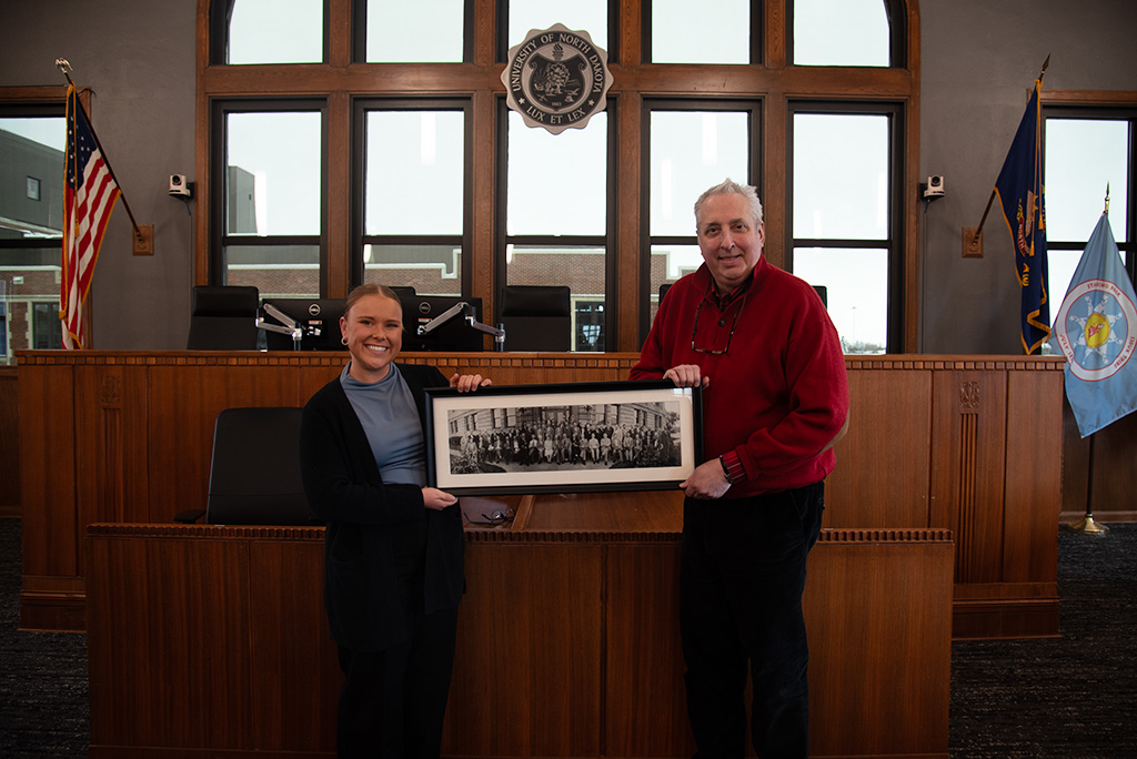 Madison Schoenberg, LWC President and Professor Paul Traynor pose with the photograph gifted by the Traynor family.