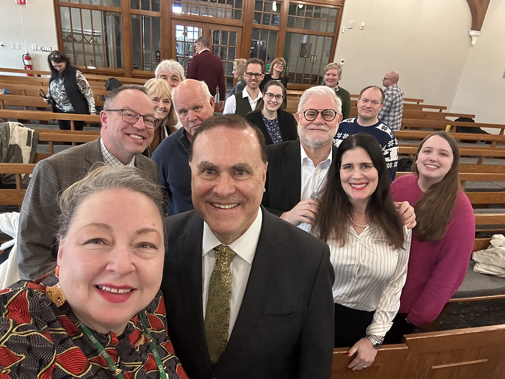 Professor Kimberly Dasse takes a selfie with Professor Gregory Gordon and some of the attendees of his book presentation event.